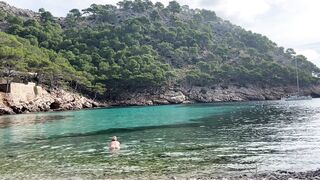 girl swimming on a public beach completely naked